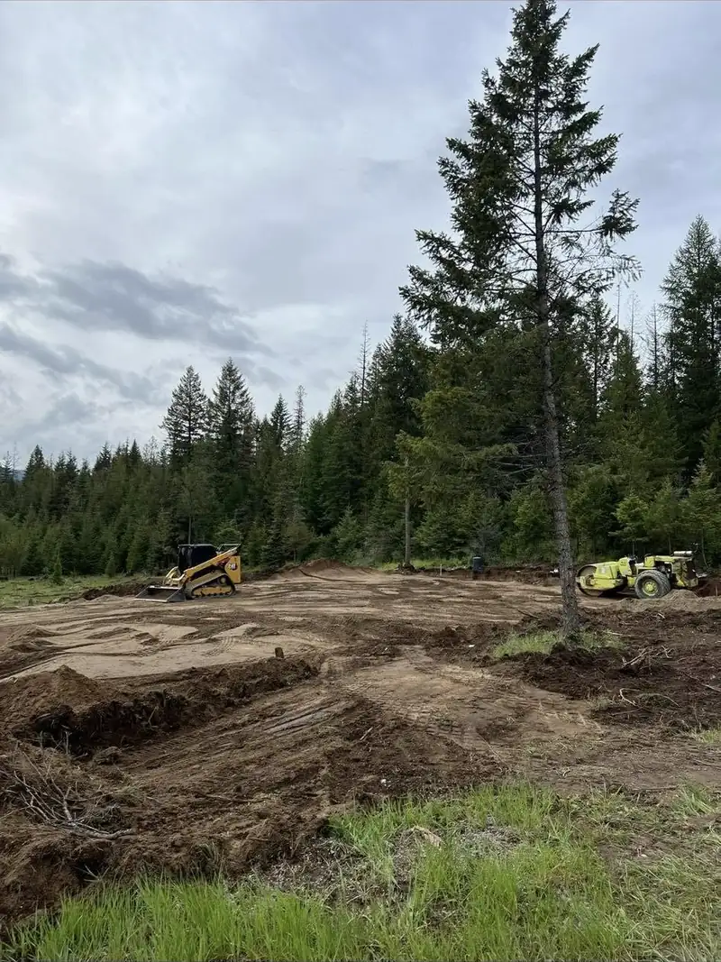 Freshly graded dirt with equipment working in the background